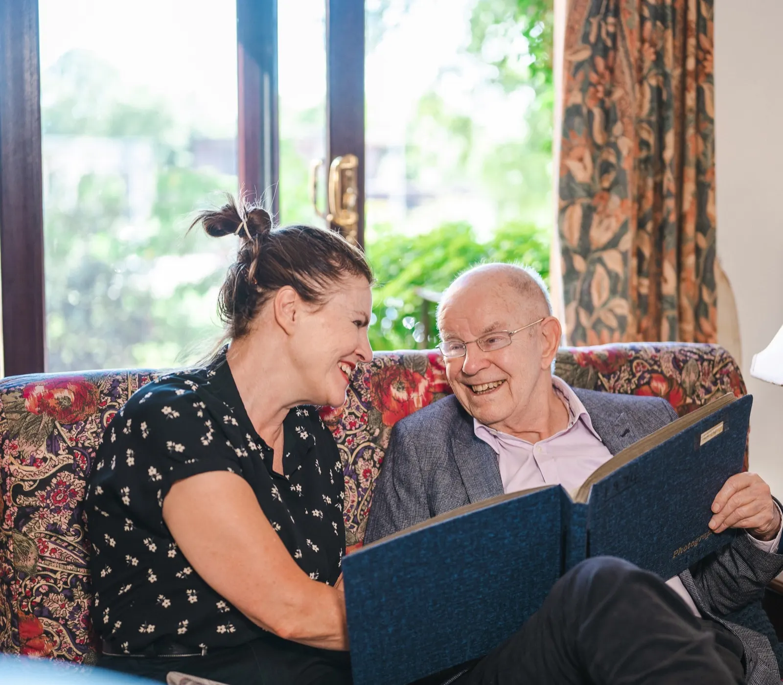 Caregiver and older adult looking at photos